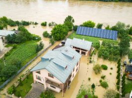 Aerial view of flooded house with dirty water all around it