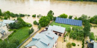 Aerial view of flooded house with dirty water all around it