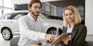 Businessman choosing auto, buying new automobile in car showroom.