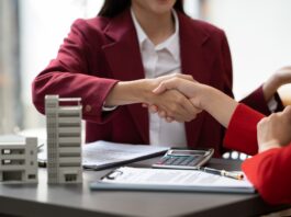 Asian businesswoman making a deal to buy a house or condo inside the office, home insurance concept