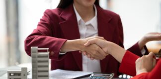 Asian businesswoman making a deal to buy a house or condo inside the office, home insurance concept