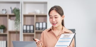 Asian businesswoman negotiates the sale of a car, discussing insurance and financing options