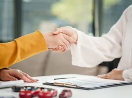 Asian businesswoman shakes hands a salesman and customer desk, discussing car sales, insurance