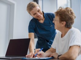 Female patient filling insurance legal document at appointment with doctor in clinic