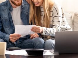 Happy married couple looking at personal finances at home