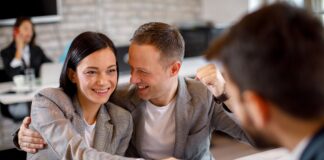 Happy young couple make a deal with their personal financial advisor in bank