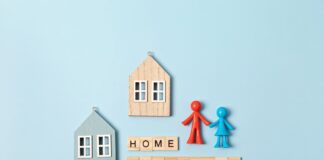 Home insurance message and wooden houses over blue background