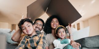 New home, family and portrait with cardboard box for moving, mortgage and property purchase. Living