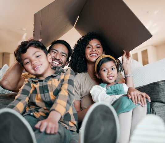 New home, family and portrait with cardboard box for moving, mortgage and property purchase. Living