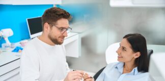 Professional stomatologist offering to sign insurance documents to female patient