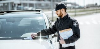 Policeman putting fine on the car